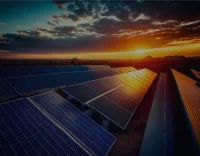 Field of solar panels in the desert with mountains and sun setting in the background